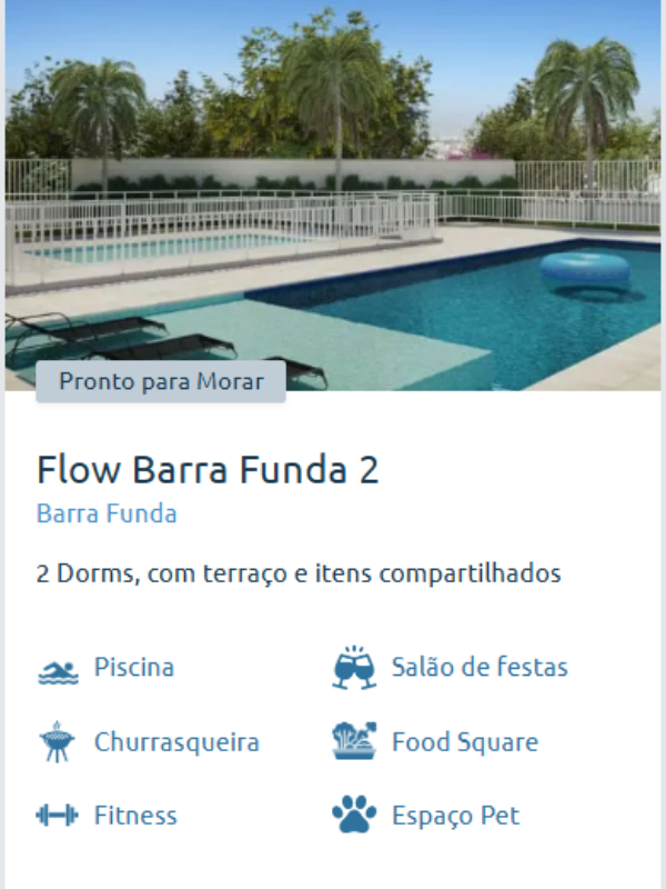 Piscina do Flow Barra Funda 2 com deck e área de descanso, cercada por vegetação e com vista da cidade.
